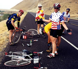 Group repairing tire on side of road.
